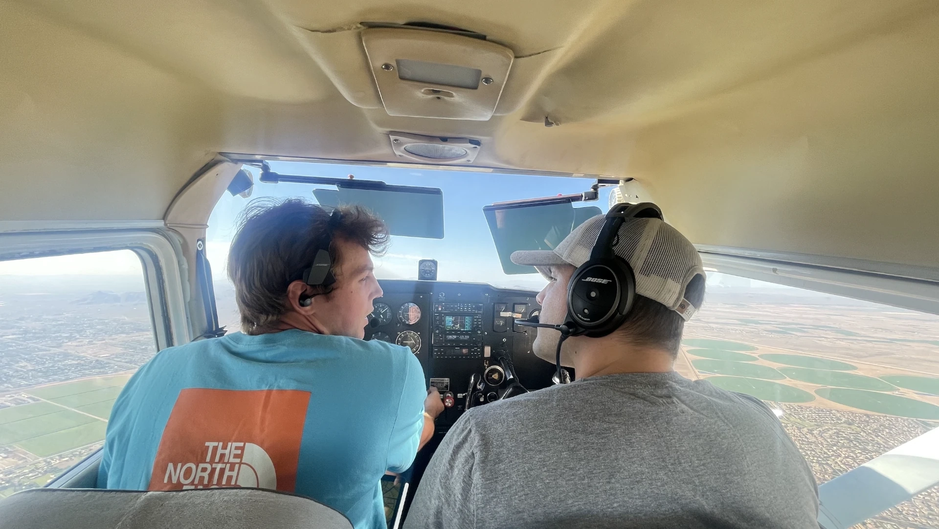Pilots seen from the back in cockpit of flying airplane