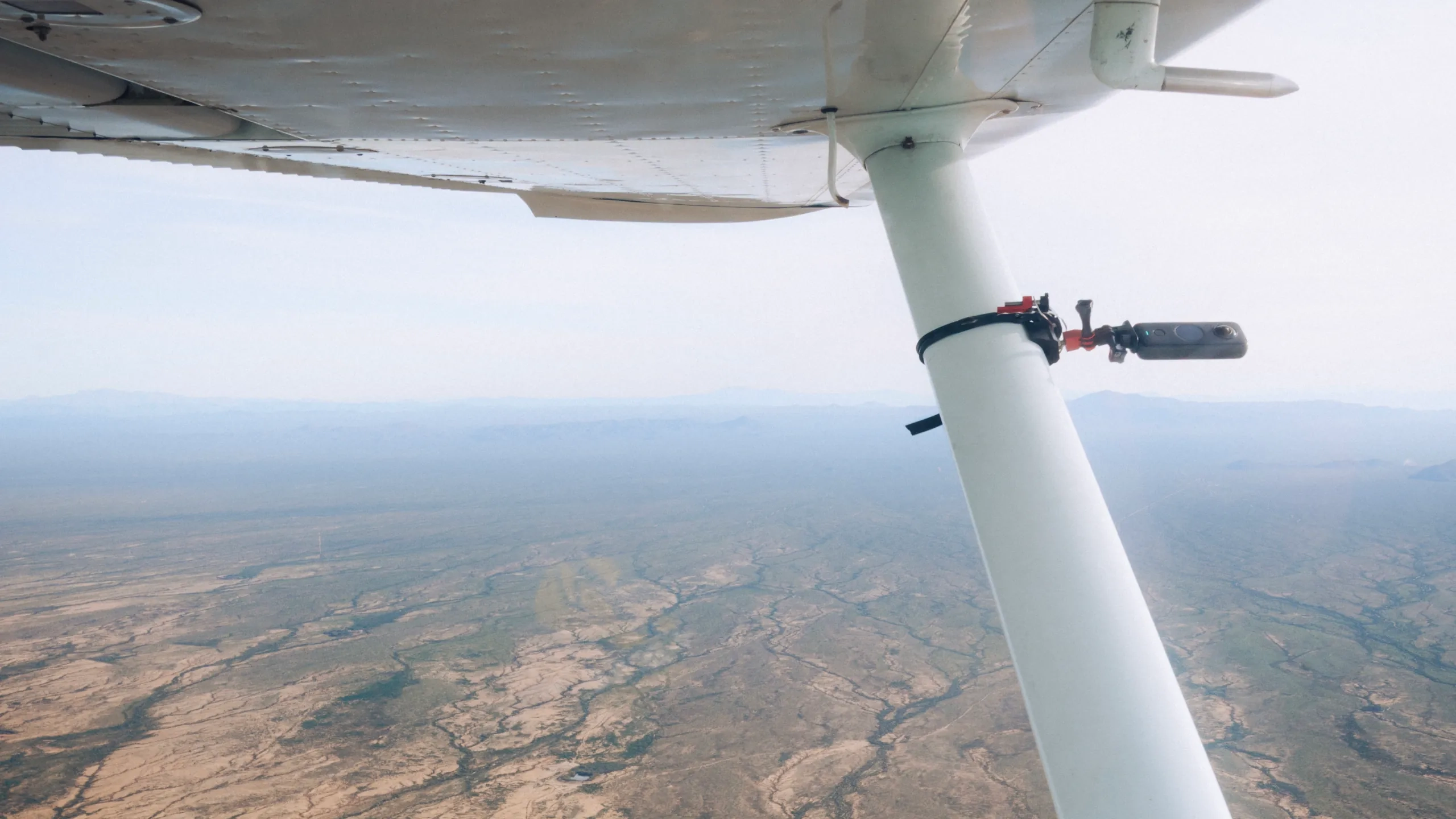 Arizona desert seen past the wing strut of a SimpliFly Flight School Cessna